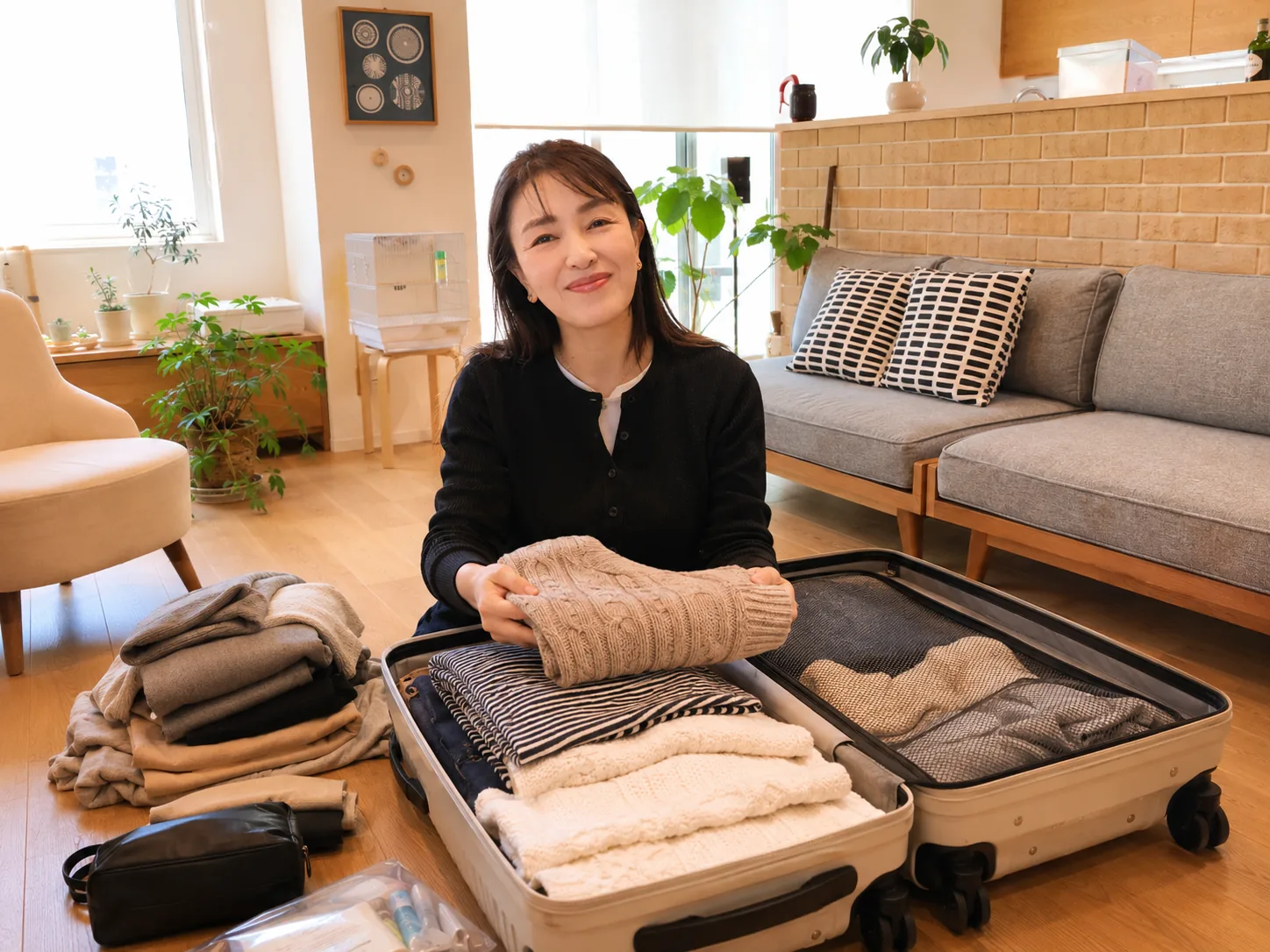 入院前日にスーツケースへ1週間分の衣類や洗面用具を詰める女性のイメージ