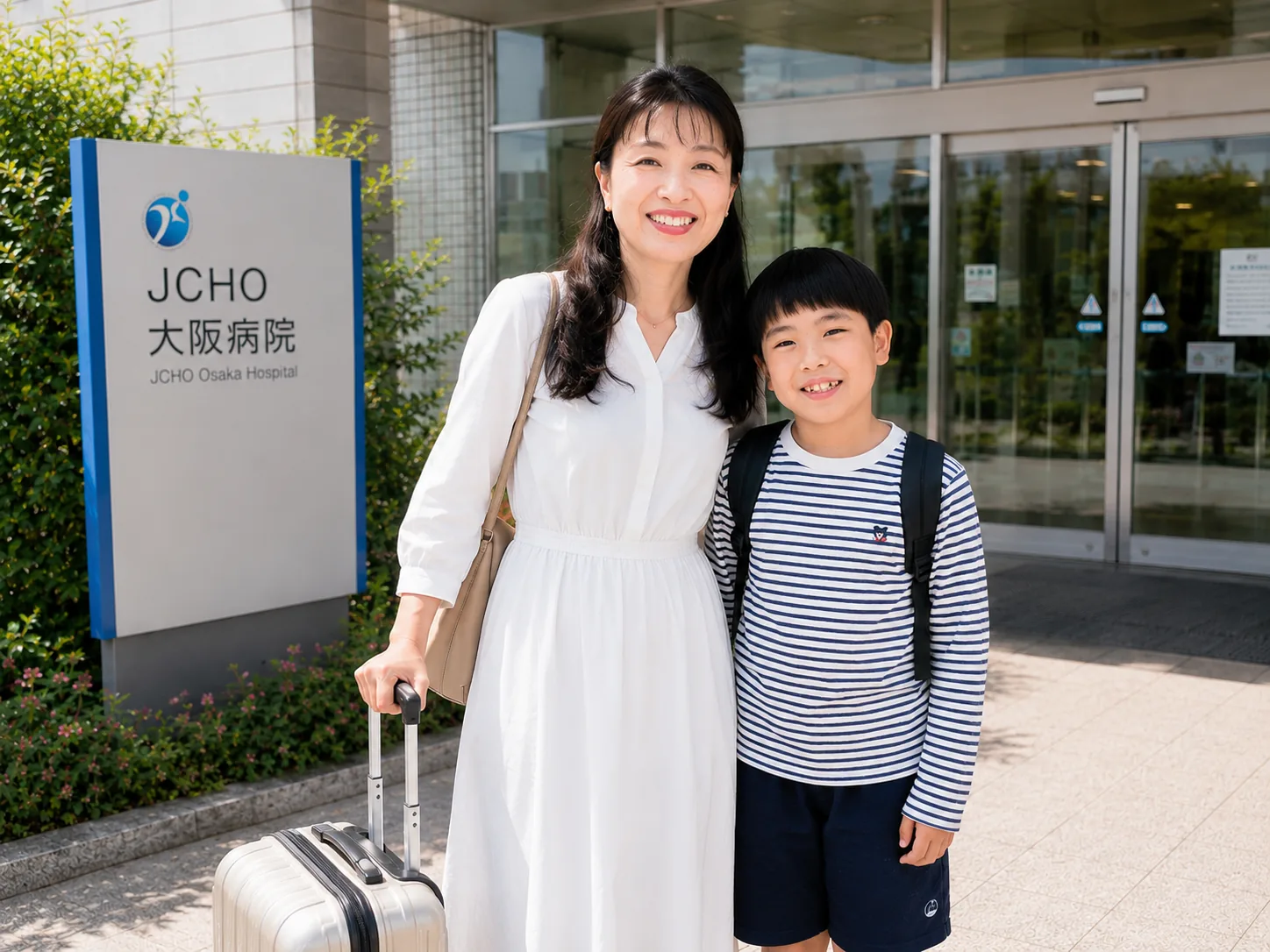 退院日にJCHO大阪病院の前でスーツケースを持ち、子どもと並んで立つ母親のイメージ