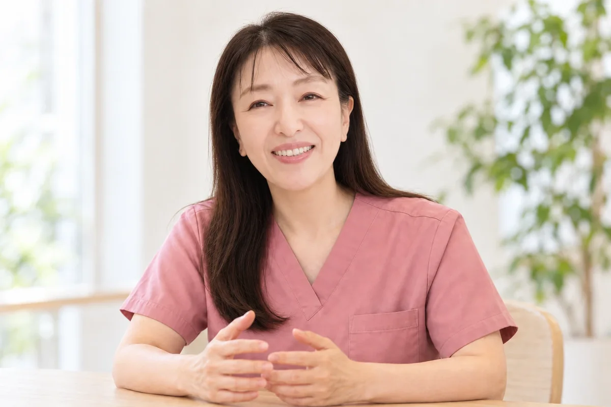 診察室で笑顔で語る院長・福田綾（ピンクのスクラブ姿）